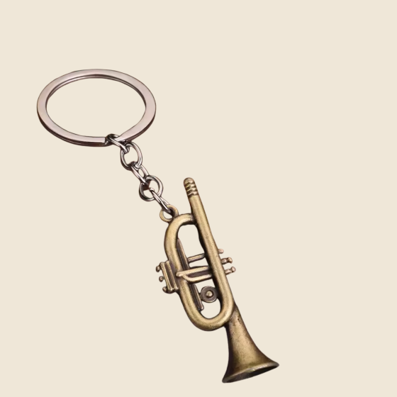 Bronze trumpet keychain on a beige background